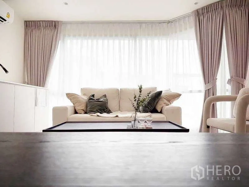 คอนโด ขายในWatthana, Bangkok - โซฟาและโต๊ะกลางหันสู่หน้าต่างเต็มบานพร้อมผ้าม่านโปร่ง