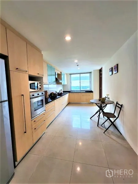 Condominium for rent in Bang Rak, Bangkok - Fitted galley kitchen with built-in oven, full cabinetry, large fridge and breakfast nook.