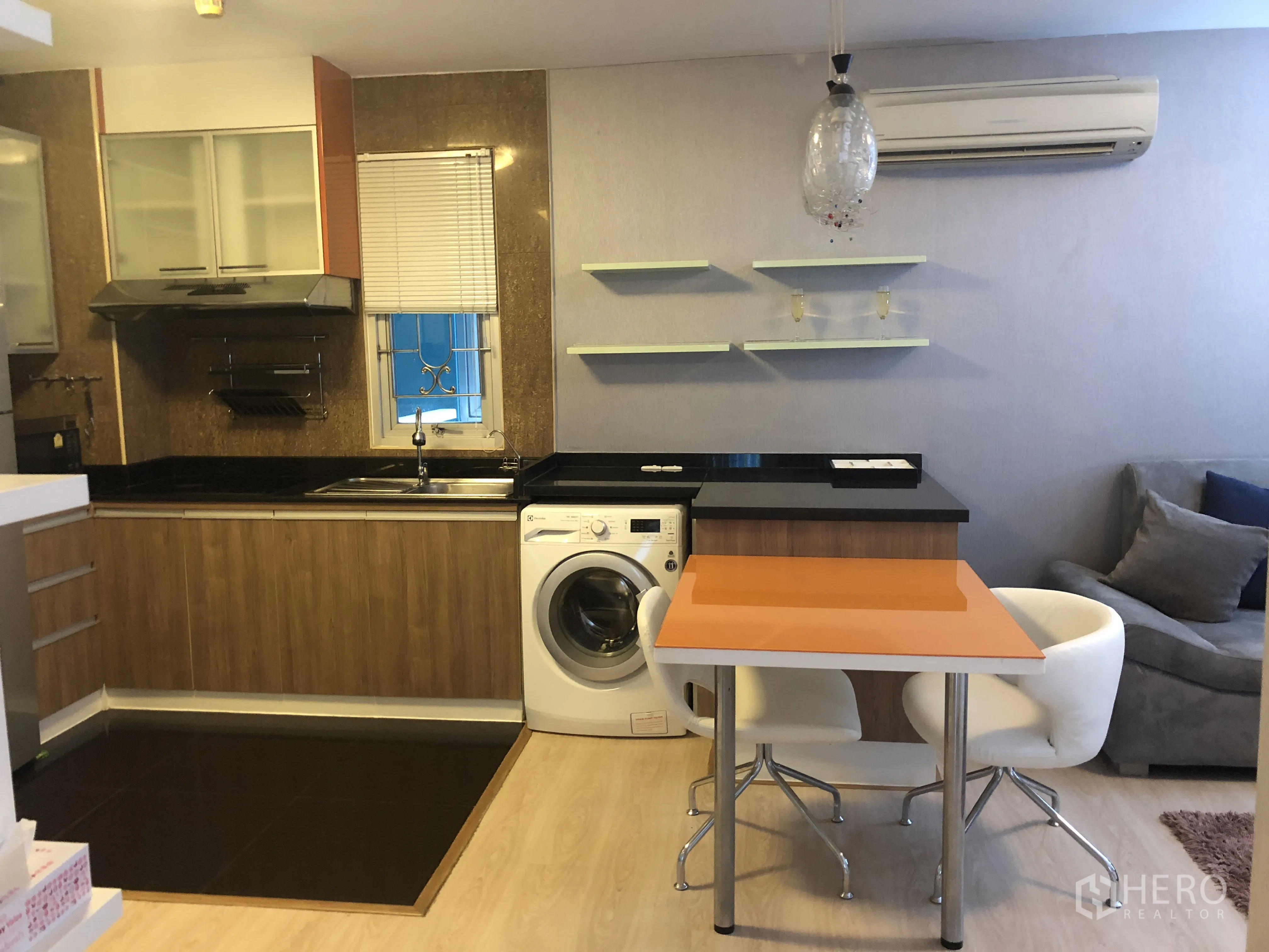 คอนโด ให้เช่าหรือขายในKhlong Toei, Bangkok - ครัวแบบเปิด ตู้ไม้ เคาน์เตอร์หินดำ อ่างล้าง และเครื่องซักผ้าข้างบาร์ทานอาหาร