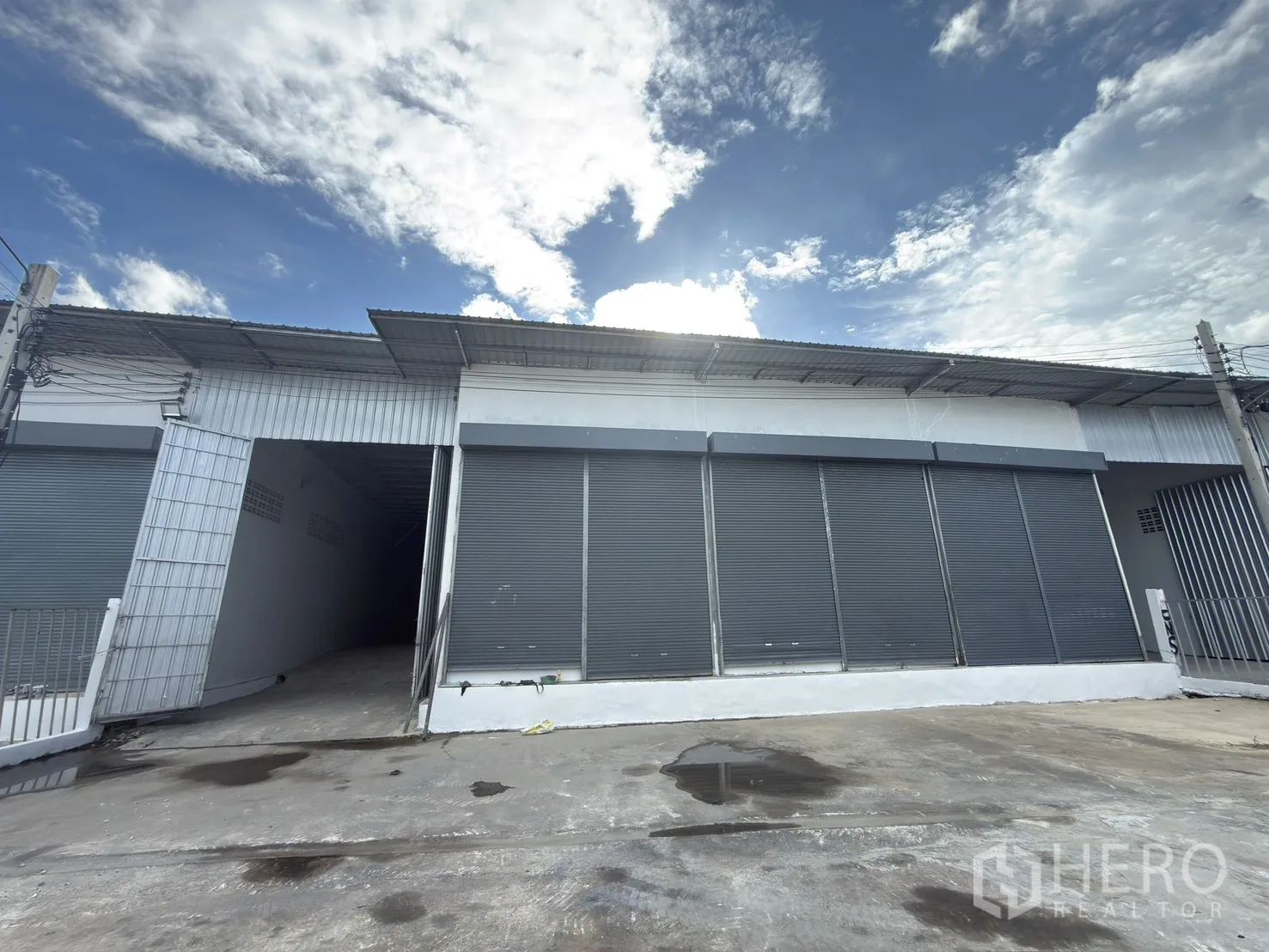 โกดัง for rent in Thawi Watthana, Bangkok - ด้านหน้าโกดังมีประตูม้วนหลายบานและลานคอนกรีตกว้าง