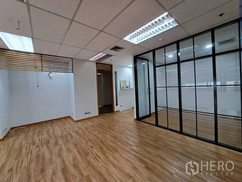 办公空间 出租在Bang Rak, Bangkok - 开放式办公室，木纹地板，吊顶照明，带黑框玻璃会议室。