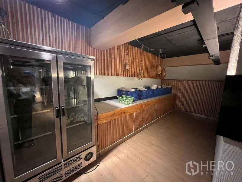 店屋 出租或出售在Khlong Toei, Bangkok - 服务吧台区，木格栅墙面、展示冰柜和储物柜。