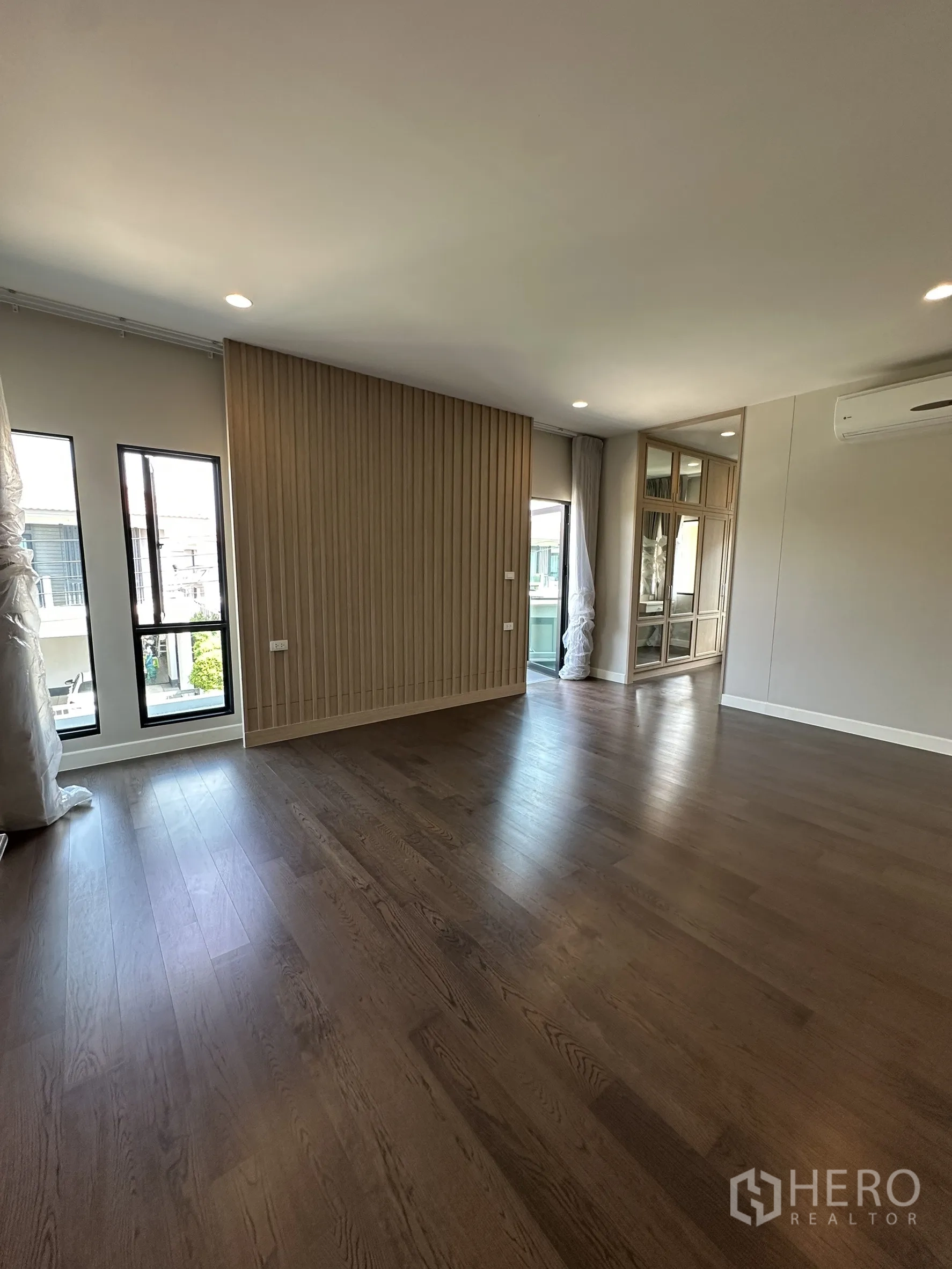 บ้าน ขายในLam Luk Ka, Pathum Thani - ห้องนอนมาสเตอร์กว้าง พื้นไม้ ผนังซี่ไม้ และมุมตู้บานกระจก