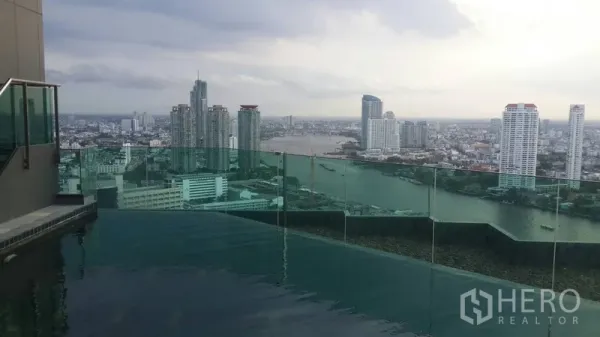 Condominium for rent or sale in Sathon, Bangkok - Rooftop infinity pool with glass railing facing a wide river and city panorama.