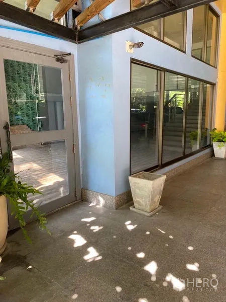 พื้นที่ขายปลีก ให้เช่าในWatthana, Bangkok - ด้านหน้ากระจกพร้อมประตูข้าง ทางเดินมีหลังคาและกระถางต้นไม้