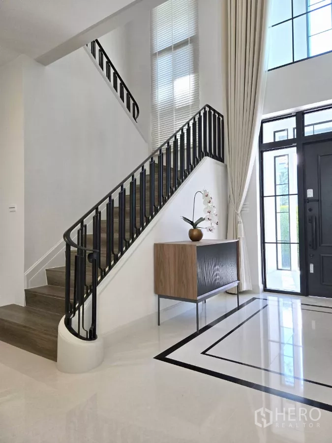 Detached House for rent in Saphan Sung, Bangkok - Double‑height foyer with modern staircase and tall windows.