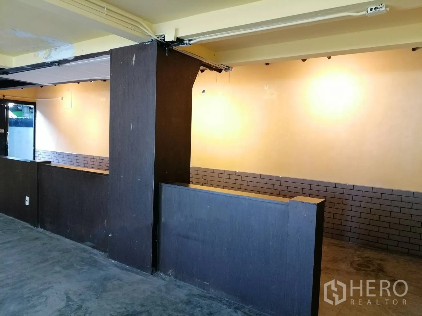 Detached House for rent in Watthana, Bangkok - Interior area with dark wood half-height partitions and softly lit painted walls.