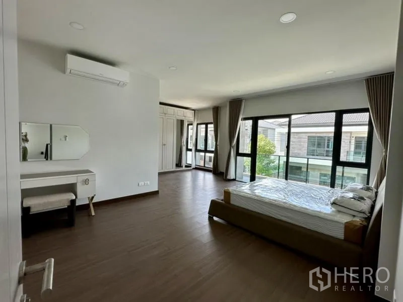 独立式住宅 出租在Bang Phli, Samut Prakan - 宽敞主卧，落地窗、衣柜与化妆台。