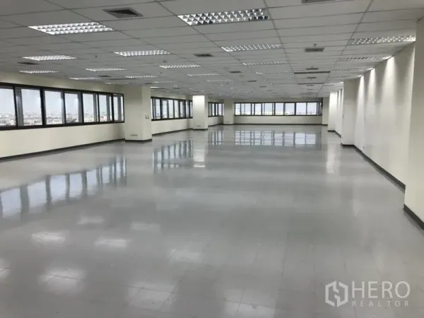 Office Space for rent in Bang Na, Bangkok - Bright corner of an open office space with tiled floors, grid ceiling, air vents and long panoramic windows in Bang Na.