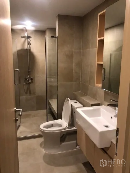 Condominium for rent or sale in Yan Nawa, Bangkok - Bathroom view showing glass shower enclosure, toilet, and wall niche shelving.