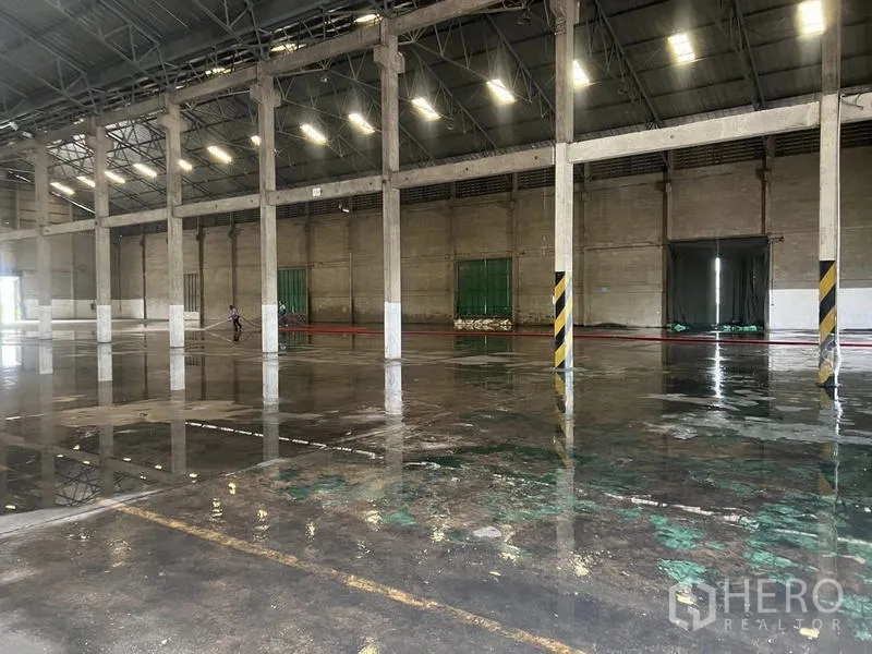 货栈 出租在Mueang Pathum Thani, Pathum Thani - 清洗后的湿地坪反射顶灯与结构立柱。