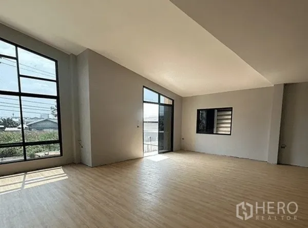 Warehouse for rent in Bang Pakong, Chachoengsao - Bright mezzanine office with floor-to-ceiling windows, sliding glass door and wood-look flooring.