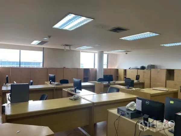 Office Space for rent in Lak Si, Bangkok - Large open workspace with rows of wooden desks, computer monitors and storage lockers.