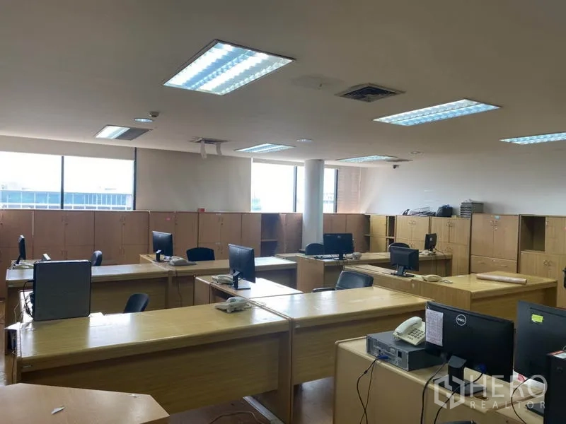 Office Space for rent in Lak Si, Bangkok - Large open workspace with rows of wooden desks, computer monitors and storage lockers.