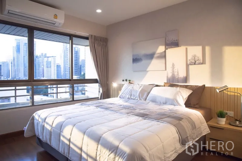 Condominium for rent in Pathum Wan, Bangkok - Master bedroom with large windows, king bed and skyline views.