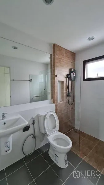 Detached House for rent in Samut Prakan - Clean bathroom with glass shower enclosure, handheld shower and wall niche.