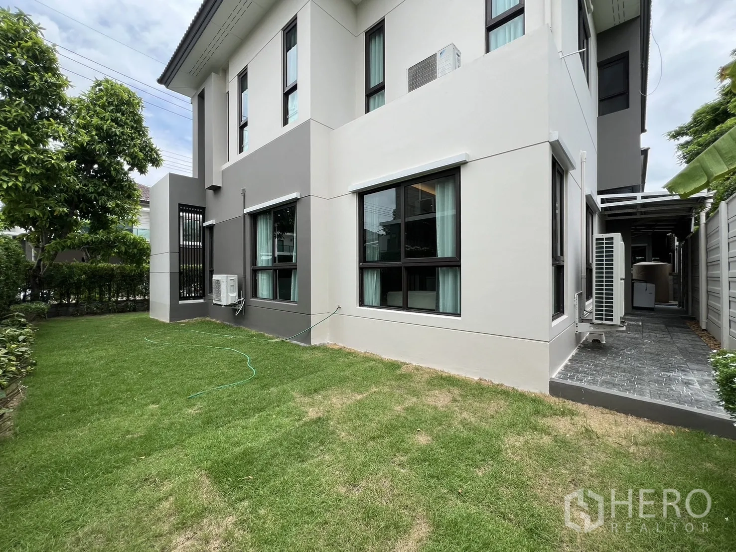 บ้าน ให้เช่าหรือขายในPrawet, Bangkok - สนามหญ้าด้านข้างโอบรอบตัวบ้าน พร้อมแนวพุ่มไม้