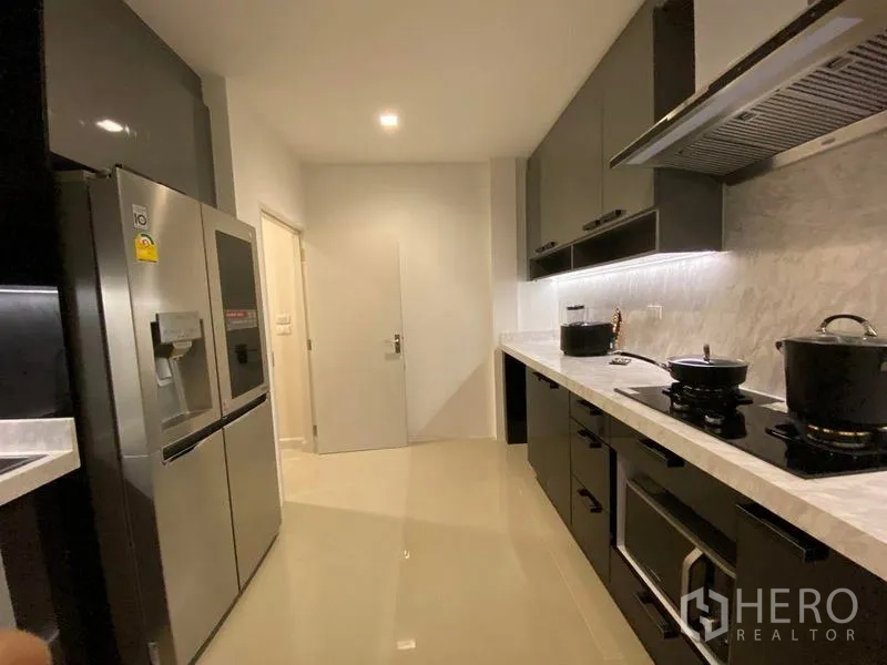 Detached House for rent - Modern kitchen with black cabinets, stone countertops and stainless refrigerator.