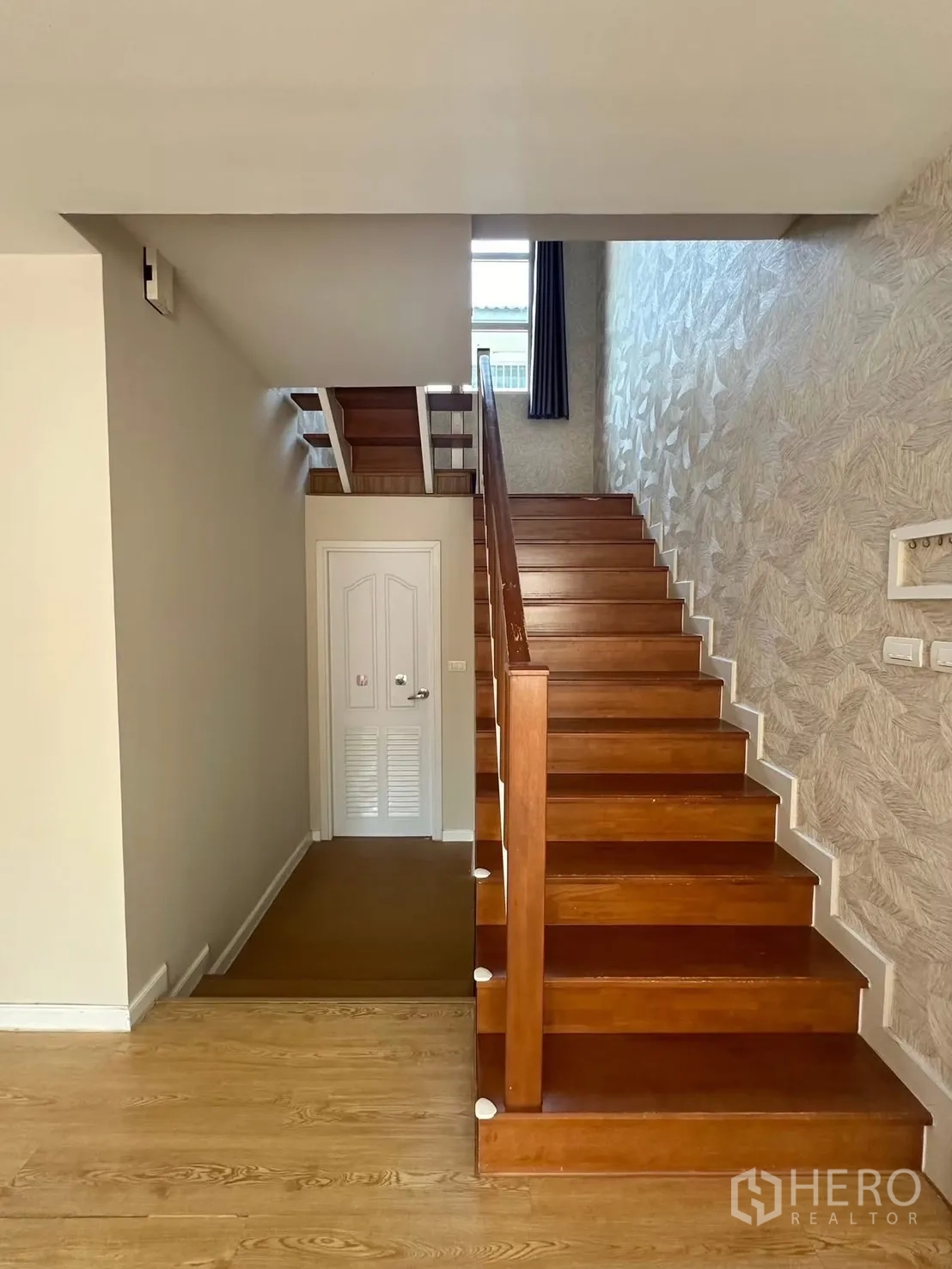 บ้าน ให้เช่า - บันไดไม้พร้อมราวสีขาวและผนังฟีเจอร์