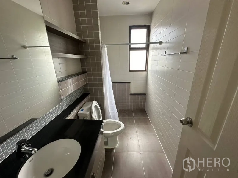 ทาวน์เฮาส์ ให้เช่าหรือขายในPhra Khanong, Bangkok - ห้องน้ำยาวมีเคาน์เตอร์ท็อปหินดำ หน้าต่าง และพื้นที่อาบน้ำ