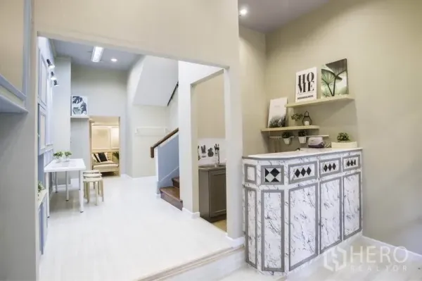 ทาวน์เฮาส์ ให้เช่าในKhlong Toei, Bangkok - โถงทางเดินพร้อมเคาน์เตอร์ลายหินอ่อน ชั้นวาง และบันไดไม้ พื้นโทนสว่าง