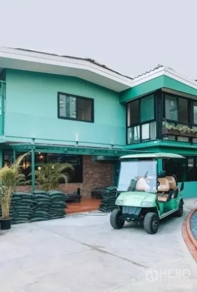 独立式住宅 出售在Khlong Toei, Bangkok - 房屋入口处摆放盆栽棕榈与园艺材料，带顶露台的两层住宅外观。