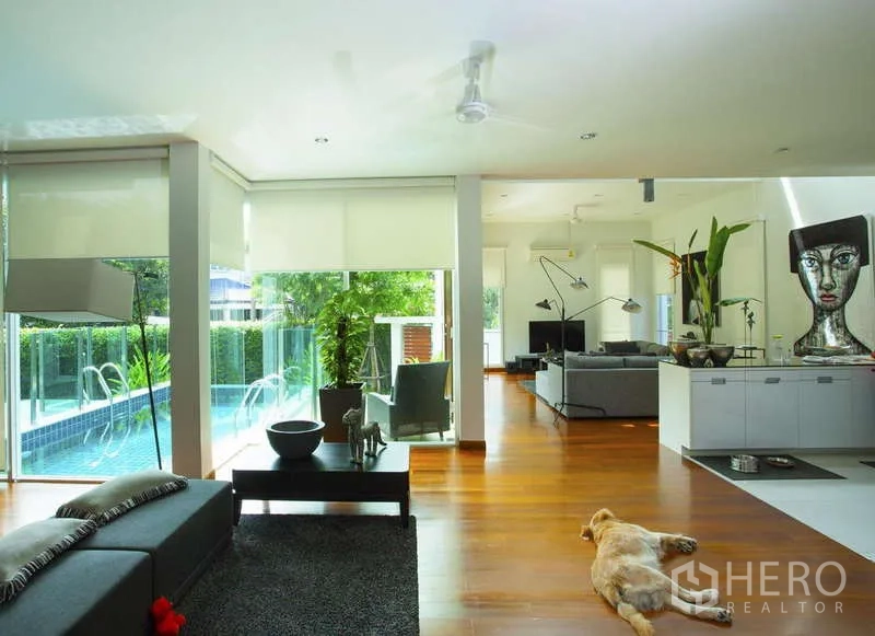 独立式住宅 出租在Lat Phrao, Bangkok - 开放式客厅，临池景观，木地板与大面积采光。