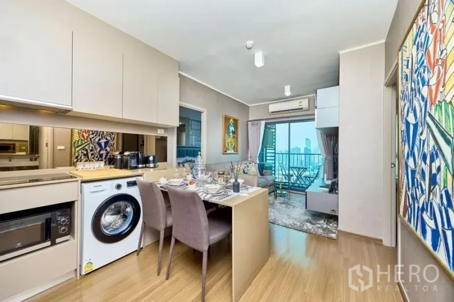Condominium for rent in Phra Khanong, Bangkok - Open-plan kitchen and dining leading to a living room with balcony and sweeping city views.