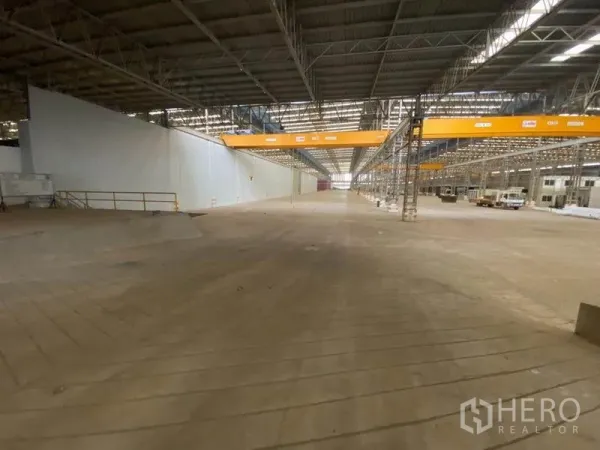 Factory for rent in Khlong Toei, Bangkok - Vast factory hall with a high steel roof, overhead gantry cranes and a wide concrete floor.