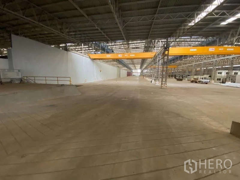 Factory for rent in Khlong Toei, Bangkok - Vast factory hall with a high steel roof, overhead gantry cranes and a wide concrete floor.