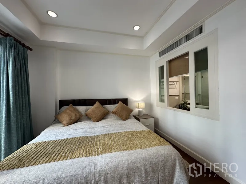 公寓 出租 - 主卧设吊顶与床头灯，内窗通向衣柜或多功能区