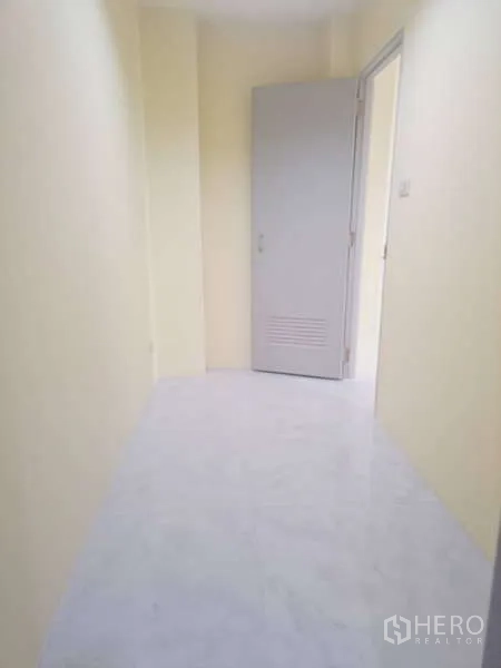 货栈 出租在Mueang Samut Prakan, Samut Prakan - 明亮走廊，白色地面通向灰色金属门。