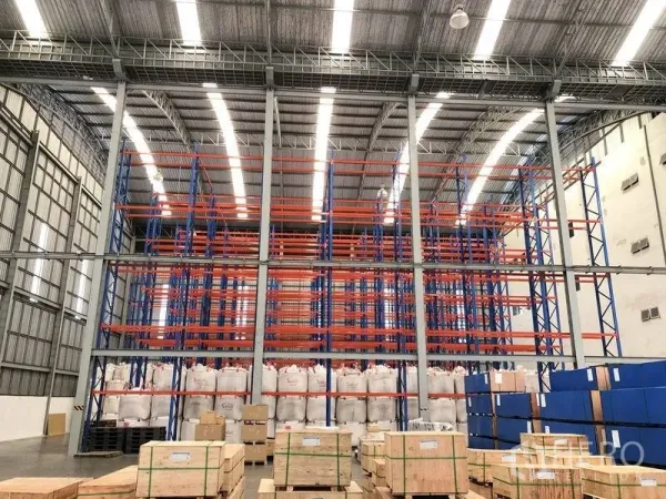 Warehouse for rent in Bang Pakong, Chachoengsao - Front view of multi-tier pallet racking system with bright strip lighting and a wide aisle for forklifts.