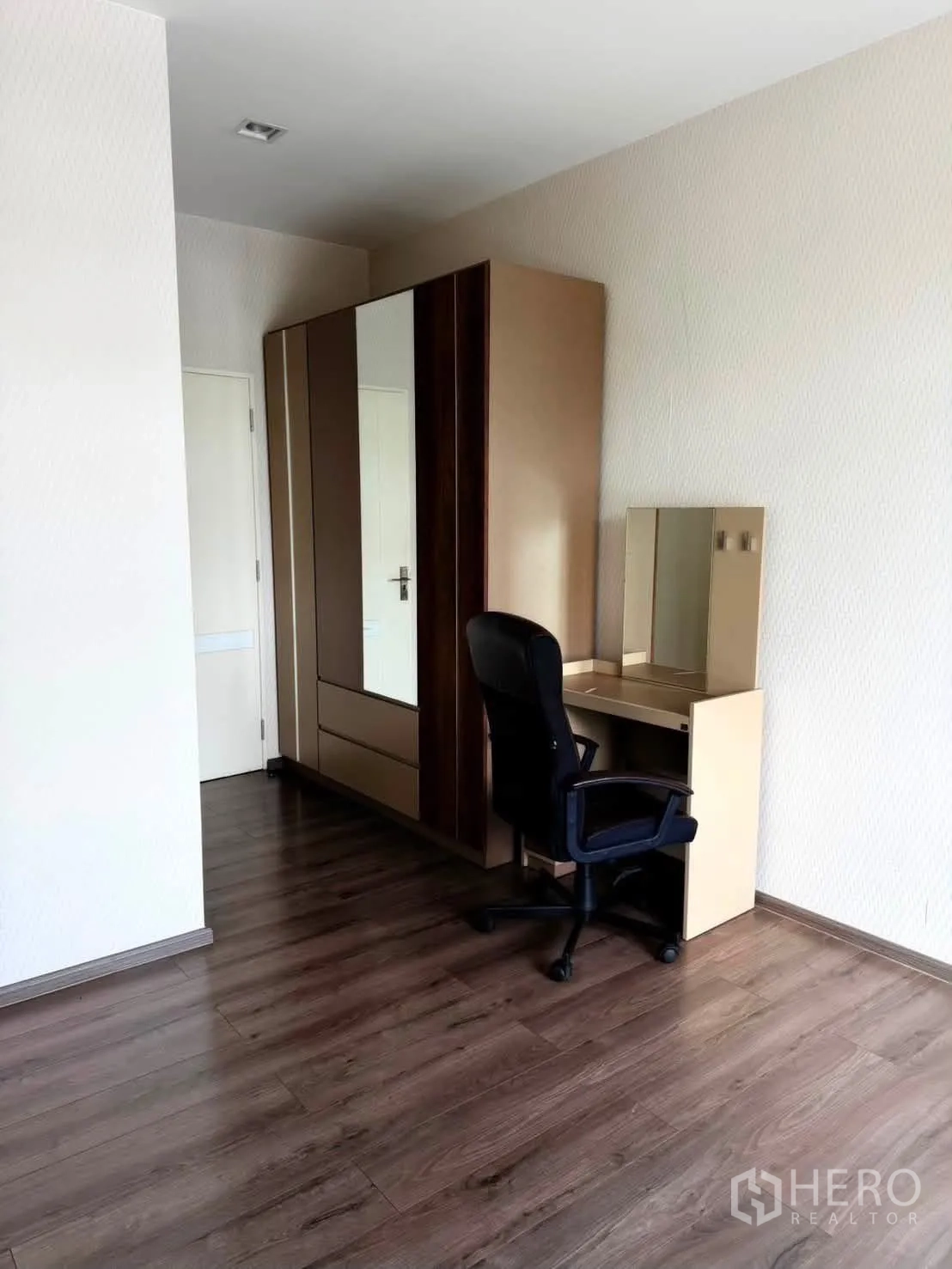 Detached House for rent in Bang Phli, Samut Prakan - Corner with wardrobe, dressing table and office chair on wood floors.