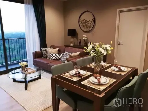 Condominium for rent in Chatuchak, Bangkok - Open-plan living and dining area with a four-seat dining table, sofa and sliding doors to the balcony.