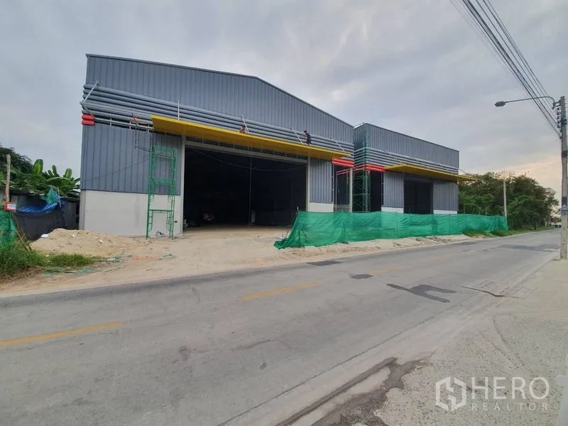 货栈 出租在Sai Mai, Bangkok - 临街仓库立面，黄色雨棚与多处装卸口。