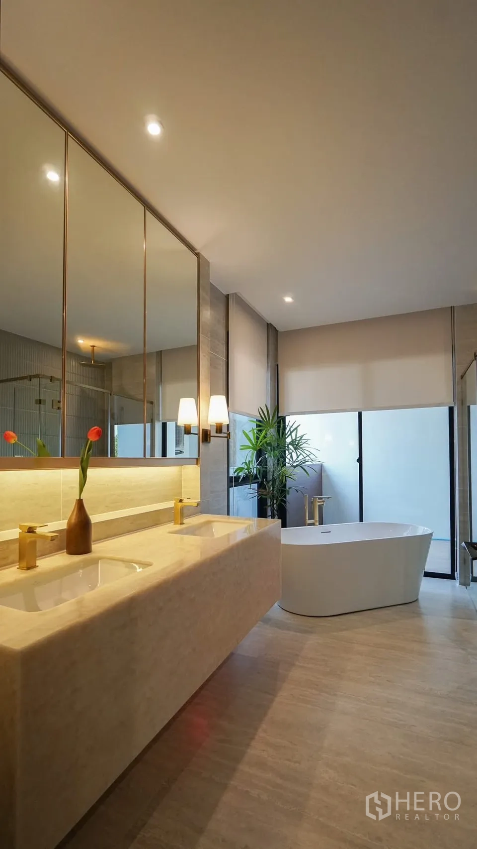 独立式住宅 出租或出售在Bang Kapi, Bangkok - 雅致卫浴，背光圆镜、石材台盆与玻璃淋浴间。