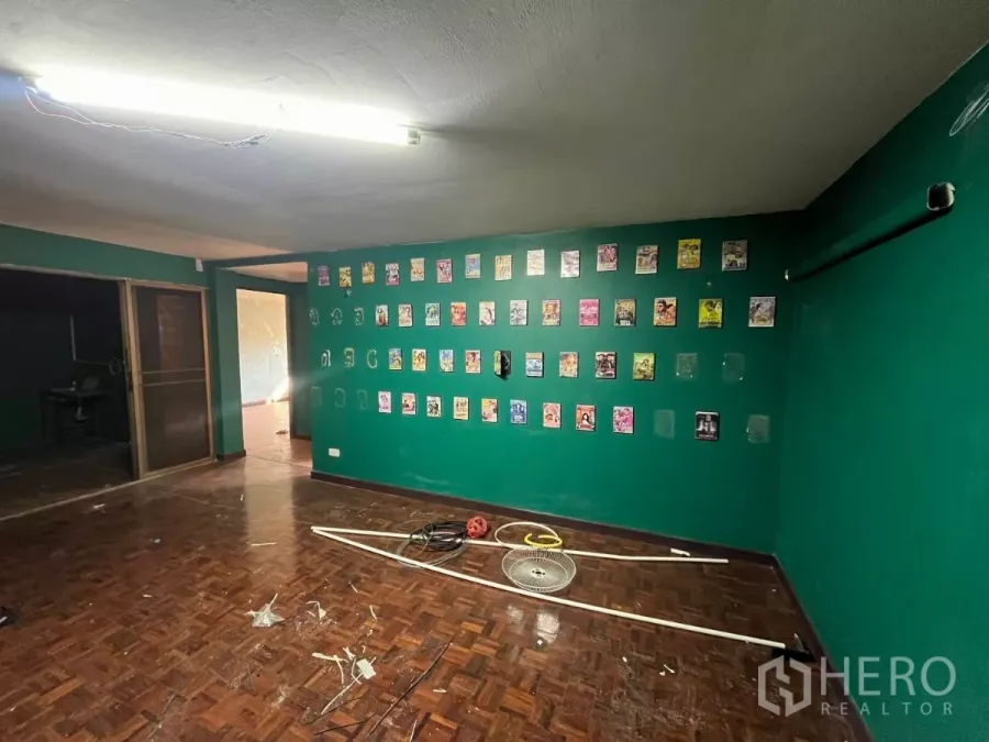 อาคารพาณิชย์ ให้เช่าในWatthana, Bangkok - ห้องกว้างผนังสีเขียว พื้นปาร์เกต์ มีภาพตกแต่งและประตูบานเลื่อนไปยังพื้นที่ถัดไป