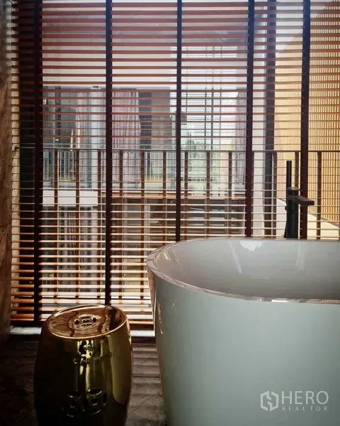 独立式住宅 出售在Lat Phrao, Bangkok - 水疗风浴室，落地窗百叶旁的独立式浴缸。