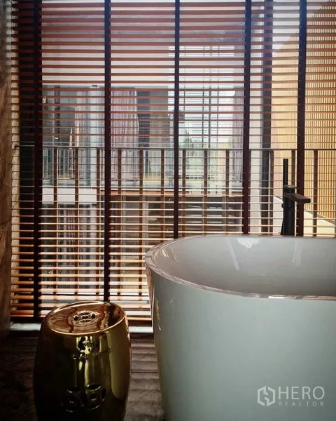 独立式住宅 出售在Lat Phrao, Bangkok - 水疗风浴室，落地窗百叶旁的独立式浴缸。