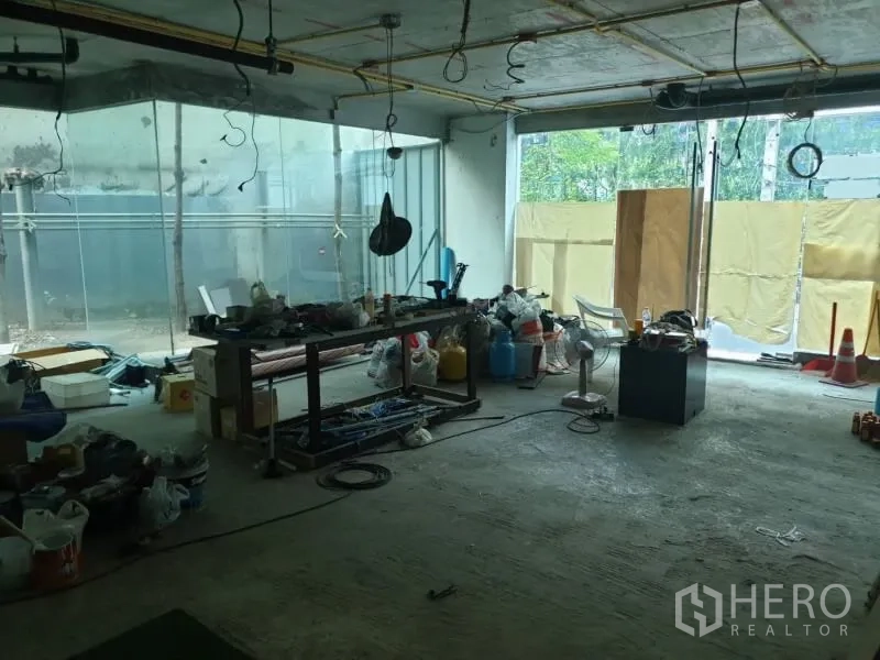 零售空间 出租在Watthana, Bangkok - 一层展厅施工中，整面玻璃门面与施工工具。
