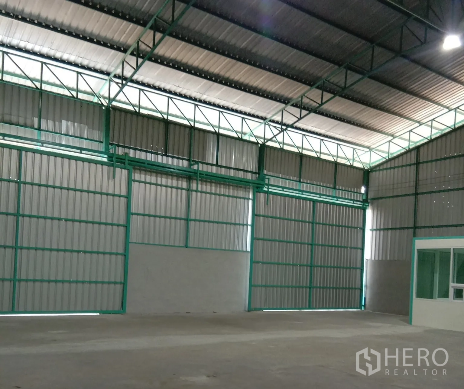 Warehouse for rent in Bang Bua Thong, Nonthaburi - Interior showing multiple loading doors, steel frames and polished concrete floor.