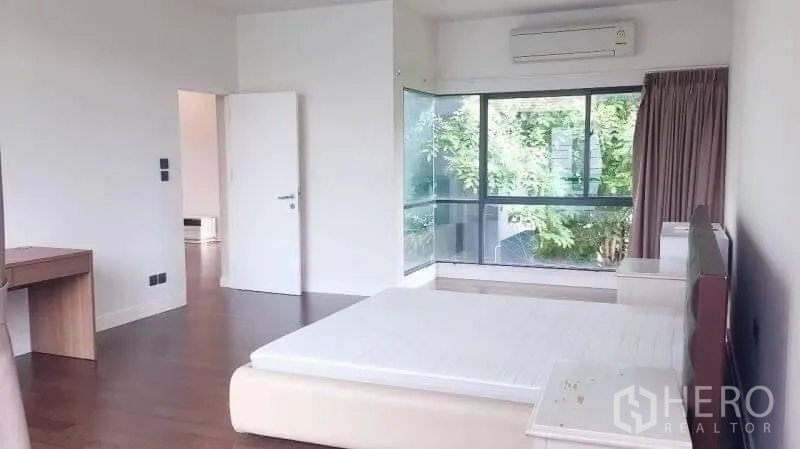 Detached House for rent in Bang Kapi, Bangkok - Corner bedroom with wraparound windows, air conditioning and leafy views.