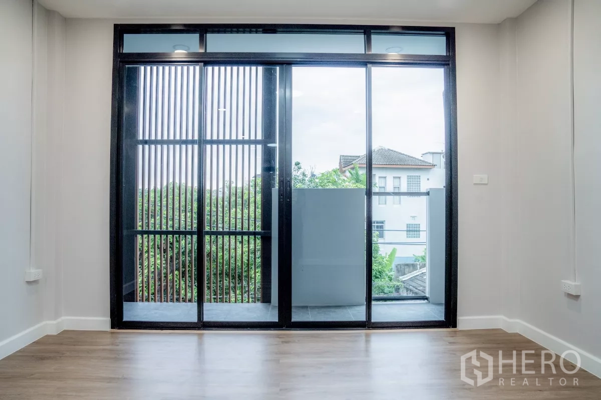 ทาวน์เฮาส์ ขายในWatthana, Bangkok - ห้องนอนมองวิวต้นไม้ พร้อมประตูกระจกเต็มบานออกสู่ระเบียงเล็ก