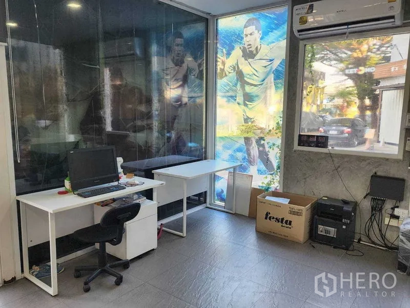 คลังสินค้า ให้เช่าในLat Phrao, Bangkok - ออฟฟิศติดแอร์ภายใน มีโต๊ะทำงาน หน้าต่างกระจก และสติ๊กเกอร์กราฟิกกีฬา