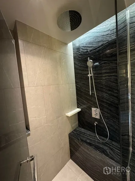 Condominium for rent in Watthana, Bangkok - Rainfall shower with bench seating and textured dark stone.