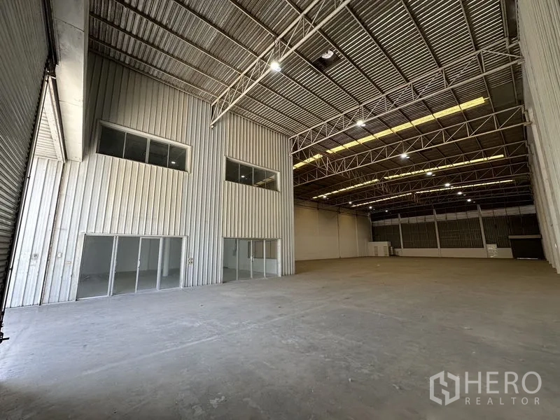 工厂 出租在Khlong Luang, Pathum Thani - 内部可见两层玻璃办公室，位于高挑通透的厂房空间内。