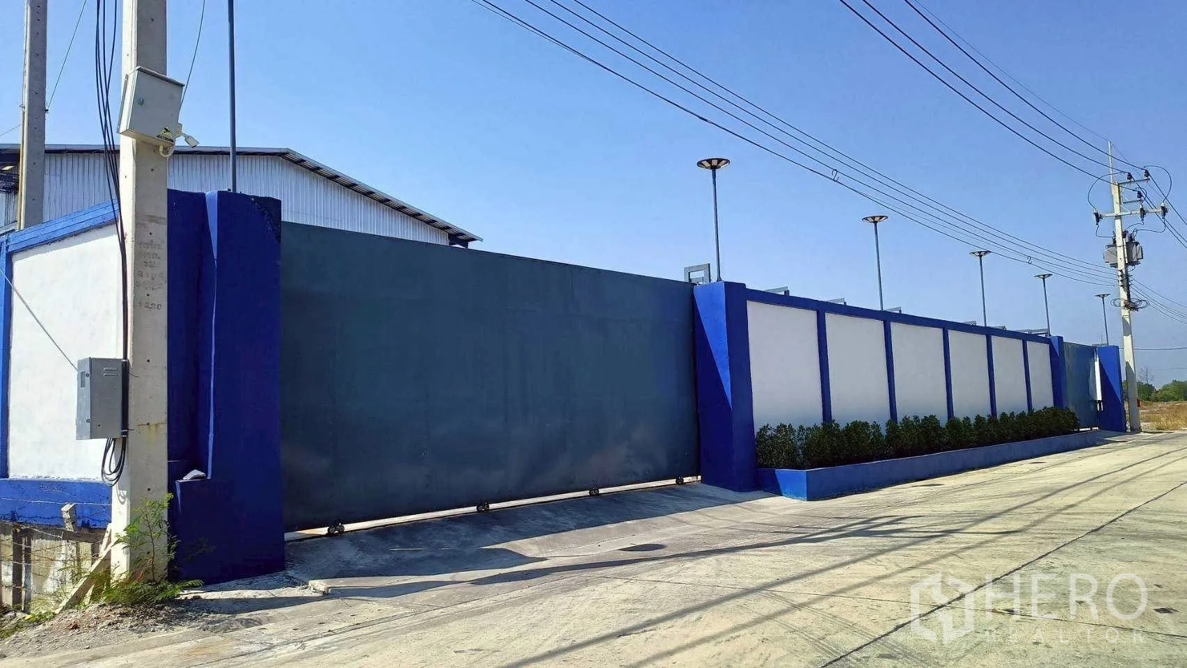 โรงงาน for rent or sale in Mueang Samut Sakhon, Samut Sakhon - มุมมองหน้าทางเข้าพร้อมกำแพงตกแต่งและพุ่มไม้