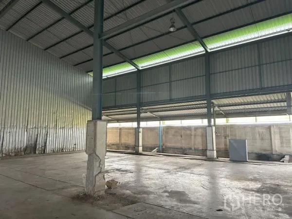 Factory for rent in Pathum Thani - Open production bay with high ceiling, translucent roof panels and concrete floor.
