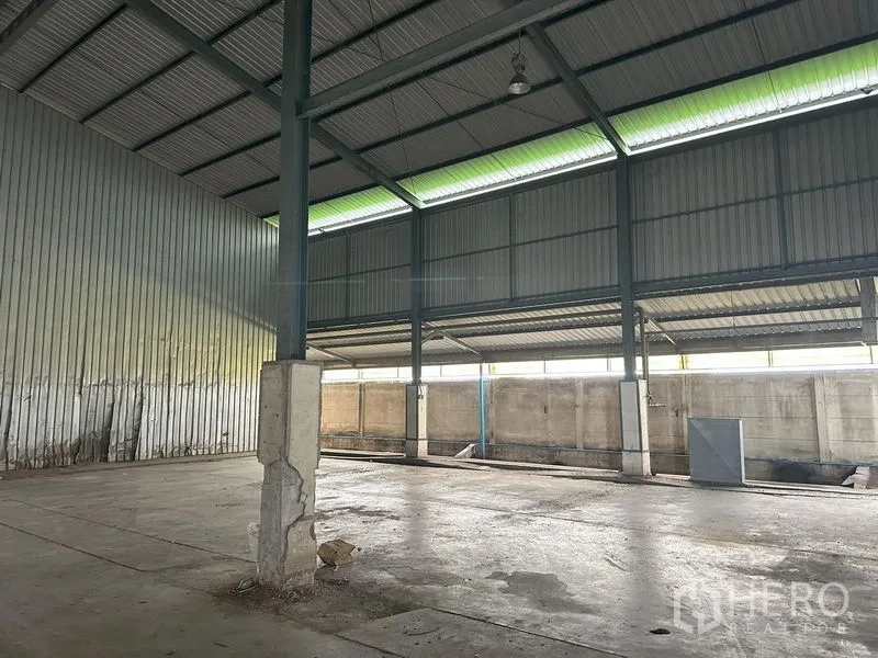Factory for rent in Pathum Thani - Open production bay with high ceiling, translucent roof panels and concrete floor.